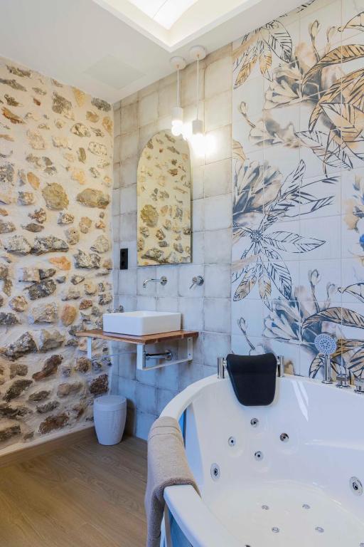 a bathroom with a tub and a sink at Portal Fosc Suites in Peniscola