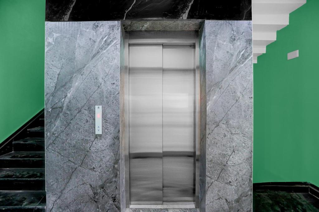 a elevator in a building with marble walls at Super Townhouse Puri Bypass Crossway Formerly Hotel Pratee Heights in Bālianta