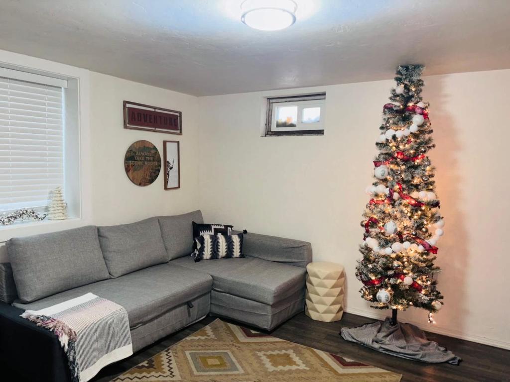 a living room with a gray couch and a christmas tree at #StayinMyDistrict Twin Falls Pendleton Chic Suite in Twin Falls