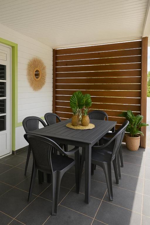 a black table and chairs on a patio at Lagon du Robert in Le Robert