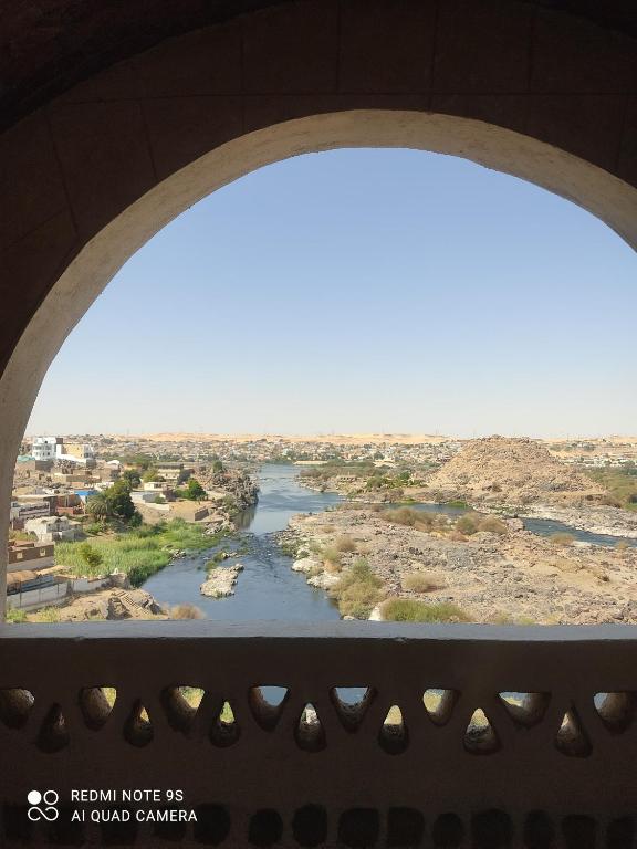 a view of a river from an arch window at Nubian Hights guesthouse in Shellal