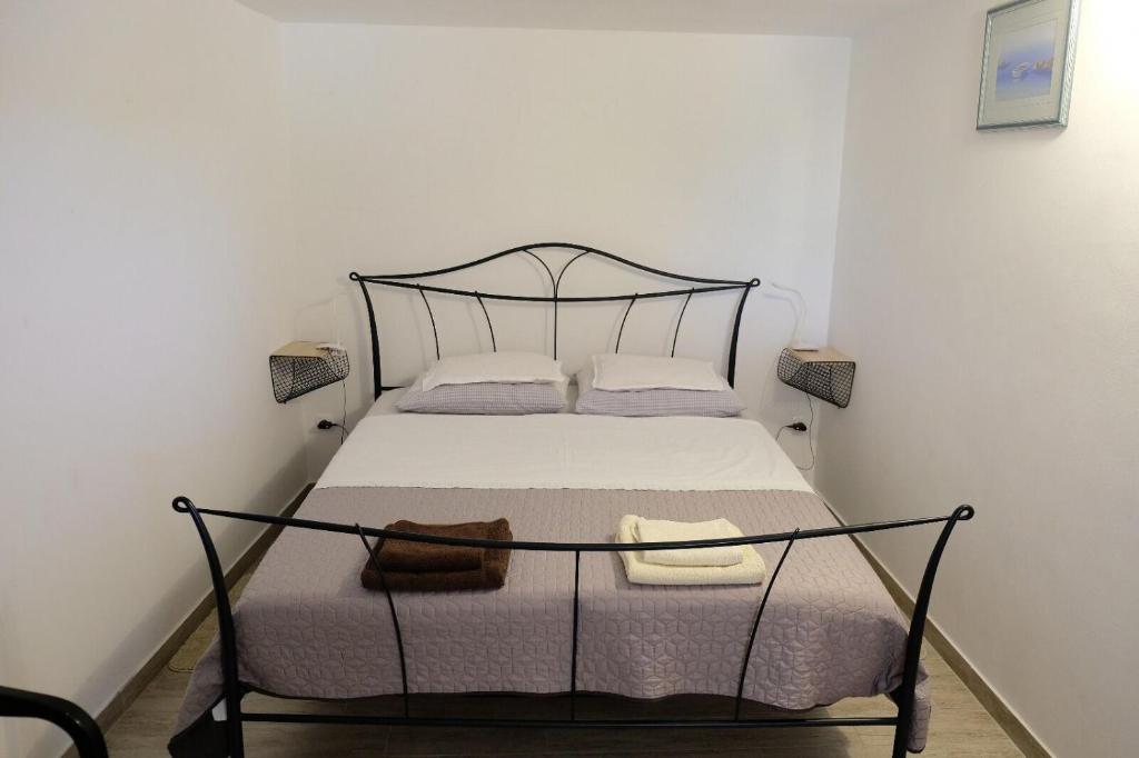 een kleine slaapkamer met een bed met een zwart frame bij House Robinson house in Dolac