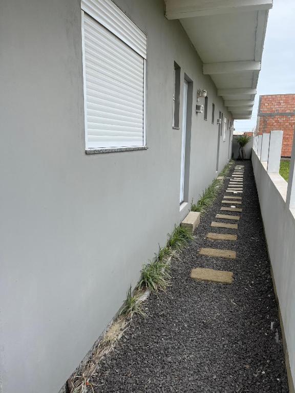 a window on the side of a white building at Havana Flats - Apto térreo 700m praia - Área Gourmet com 3 churrasqueiras in Balneário Gaivotas