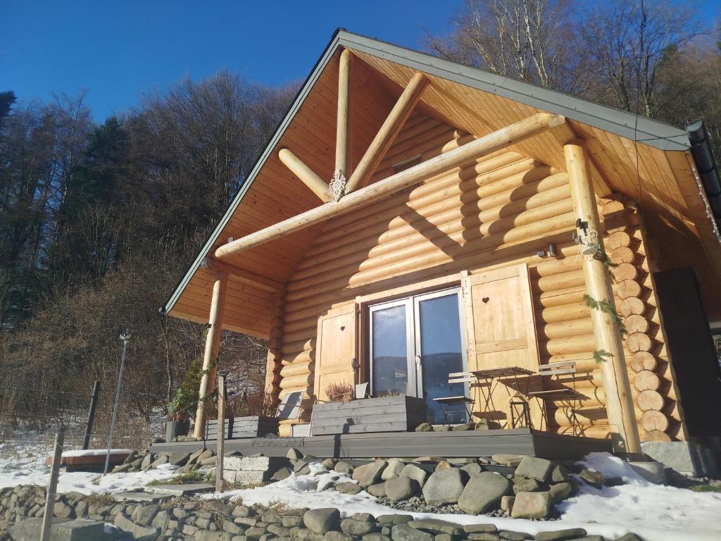 una baita di tronchi con veranda nella neve di Chatka pod lasem Szczyrk a Szczyrk