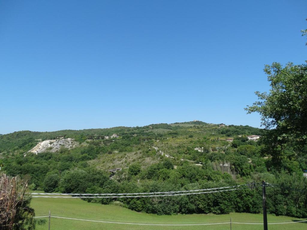 una pista de tenis en la cima de una colina en Agriturismo La Poderina, en Bagno Vignoni