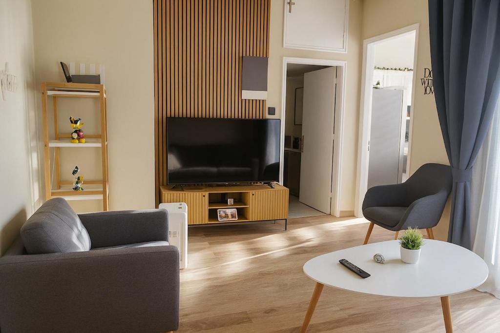 a living room with a tv and a couch and a table at Mi Casa Chios in Chios