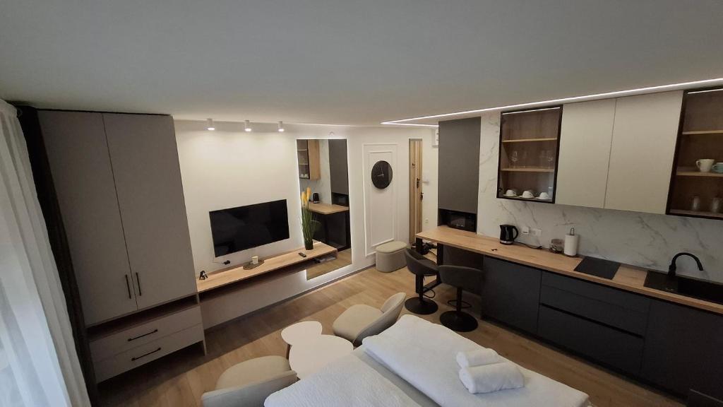 ein Wohnzimmer mit einem weißen Sofa und einem Fernseher in der Unterkunft Studio apartman OAZA in Vukovar