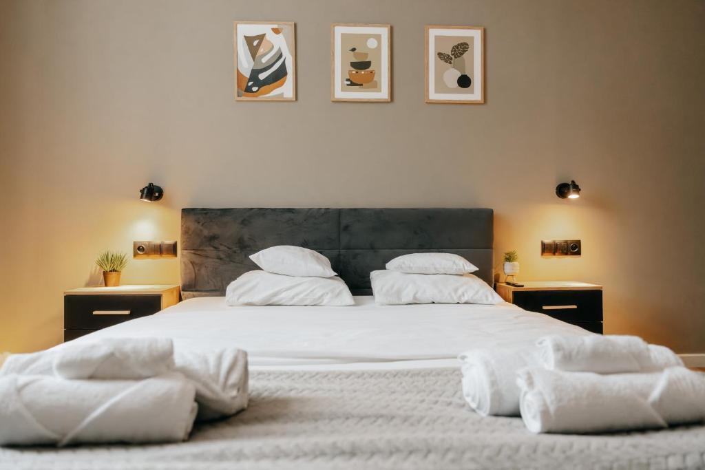 a bedroom with a large bed with white sheets and pillows at Lusia Apartment in Jarosław