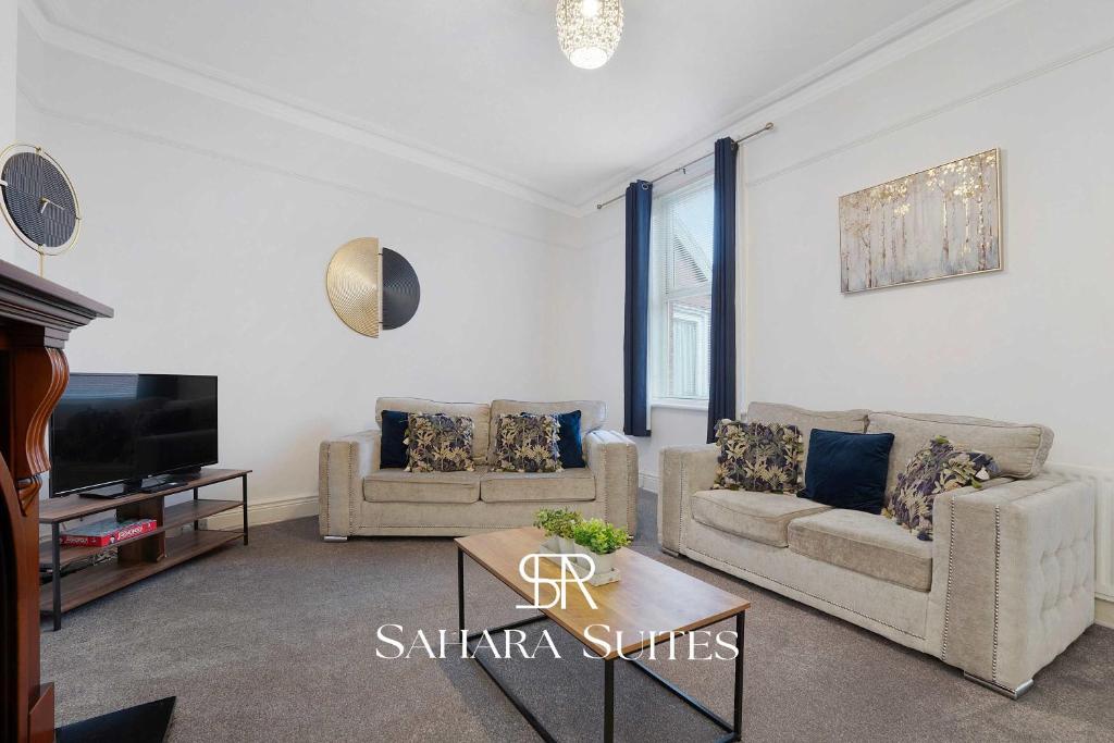 ein Wohnzimmer mit zwei Sofas und einem Fernseher in der Unterkunft Stylish 4BR South Shields Home - Contractors & Family Stay in Westoe
