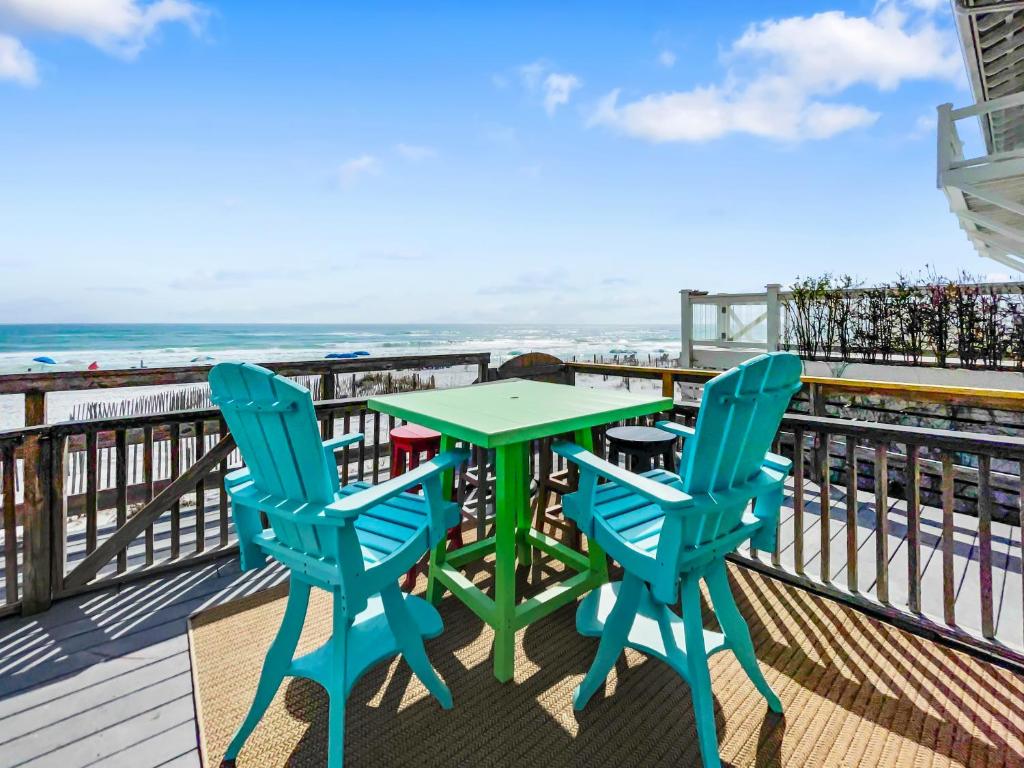 einen Tisch und zwei Stühle auf einer Terrasse mit Strand in der Unterkunft Leeward II 3 l Beachfront Condo l Large first level deck with steps down to sand in Watersound Beach