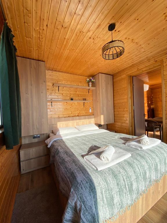 ein Schlafzimmer mit einem Bett in einem Holzzimmer in der Unterkunft Lazeti Inn • ლაზეთი ინნ in Batumi