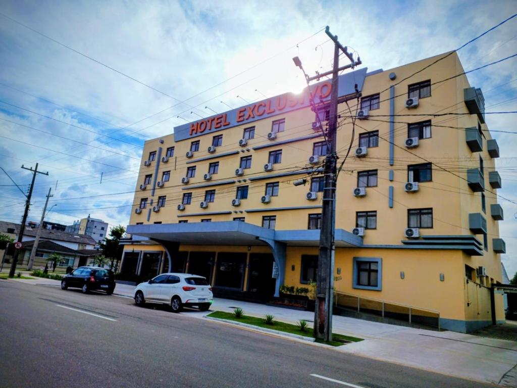 a hotel building with a car parked in front of it at Hotel Exclusivo in São José dos Pinhais