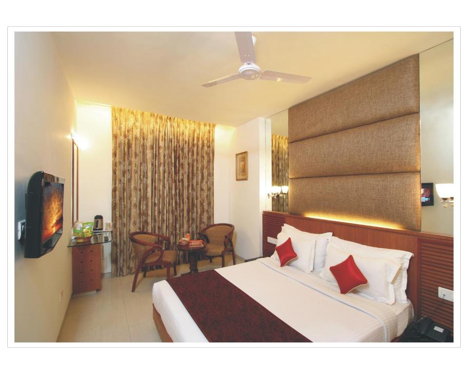 una habitación de hotel con una cama grande y una mesa en Southern Regency, en Nueva Delhi