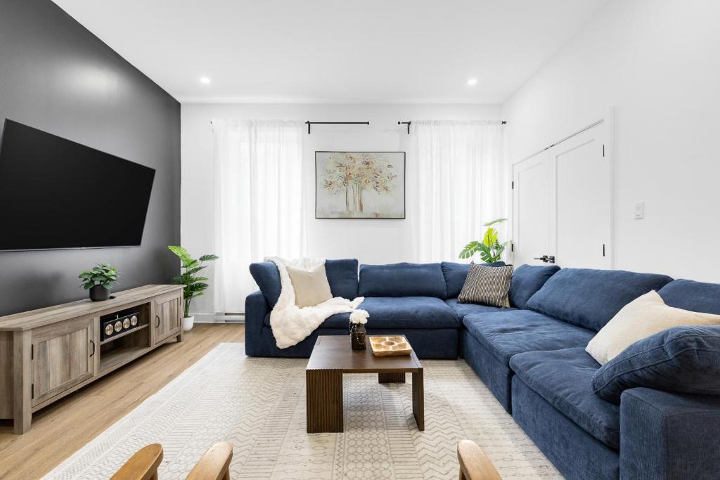 un soggiorno con un divano blu e una TV di Downtown Penthouse 2 Level-4BDRS-8Guests a Montréal