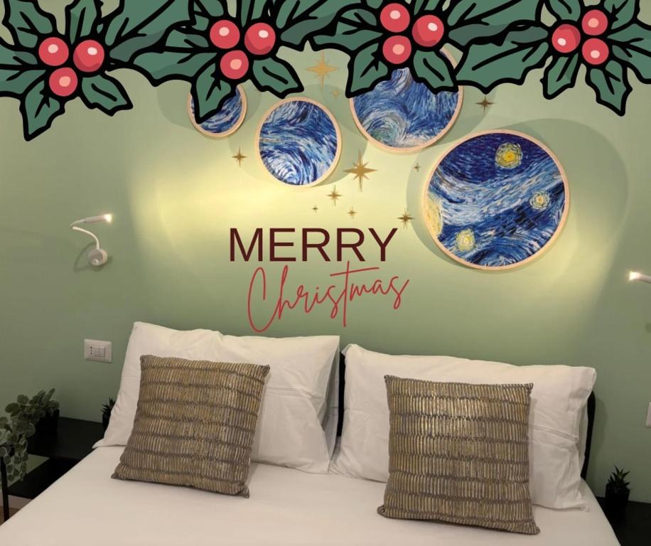 a bedroom with a merry christmas sign above a bed at Grande Cittadella Rooms in Genova