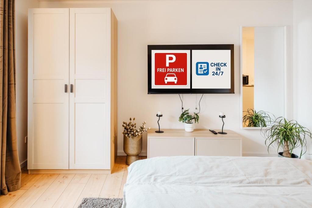 a bedroom with a bed and a tv on a wall at Elegantes Apartment in Bad Pyrmont