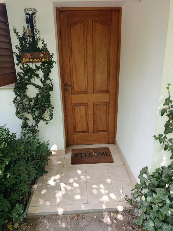 a door with a welcome sign in front of it at Das Kleine Nest in Villa General Belgrano