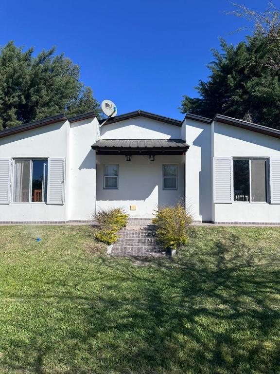una casa blanca con un patio de césped en Bungalows El Amanecer, en Colón
