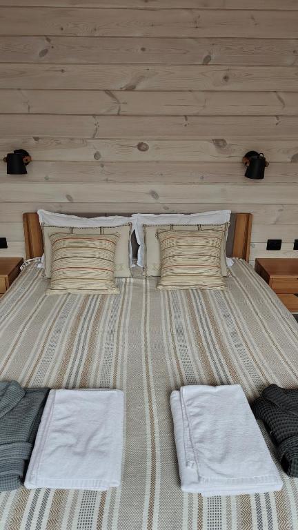 ein großes Bett mit zwei Kissen darauf in der Unterkunft Лісове SPA in Vishenki