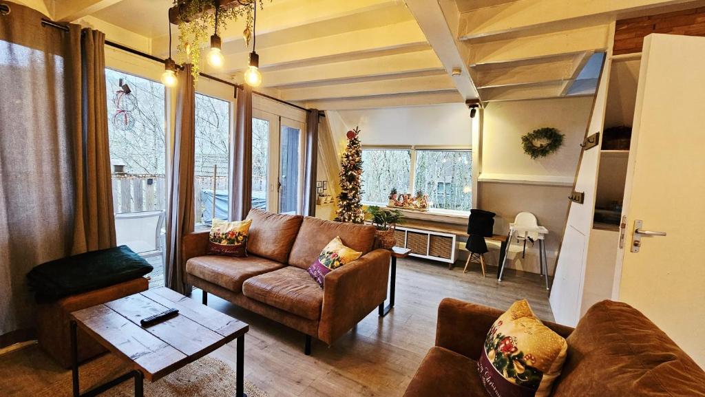 una sala de estar con un sofá y una mesa en de bosdriehoek II, en Durbuy