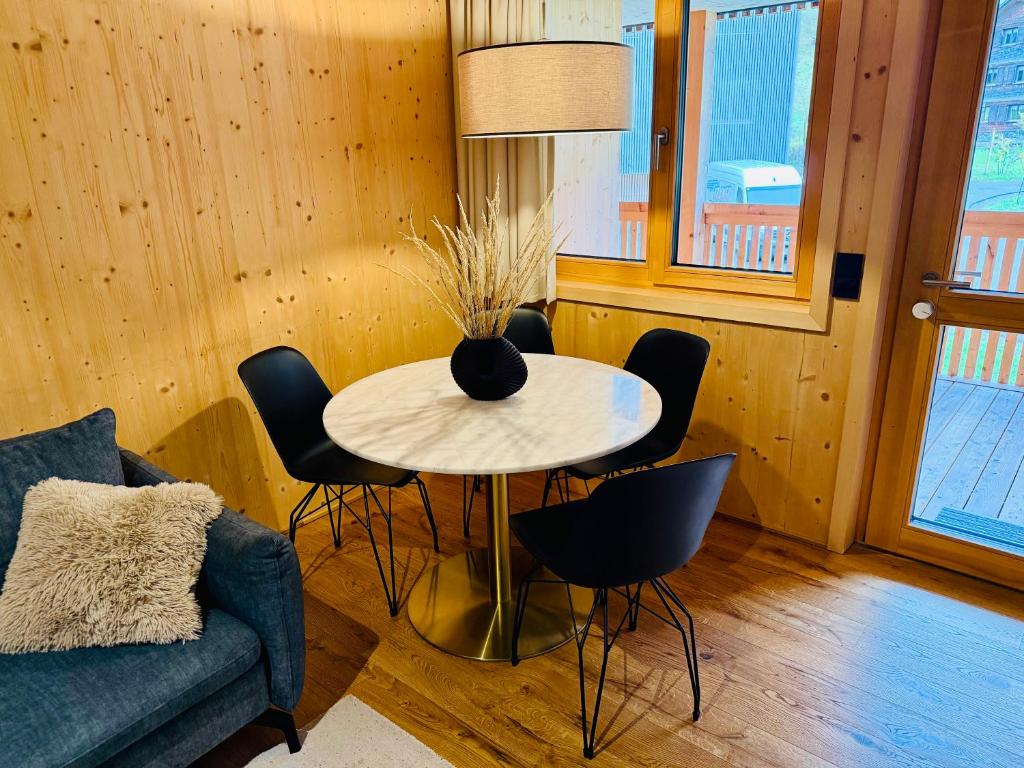 a living room with a table with chairs and a couch at Mellau Apartments in Mellau