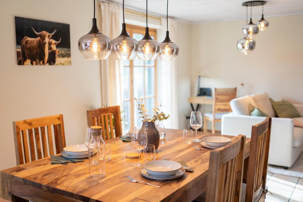 un tavolo in legno con sedie e una sala da pranzo di Gemütliche Ferienwohnung am Kochelsee a Schlehdorf
