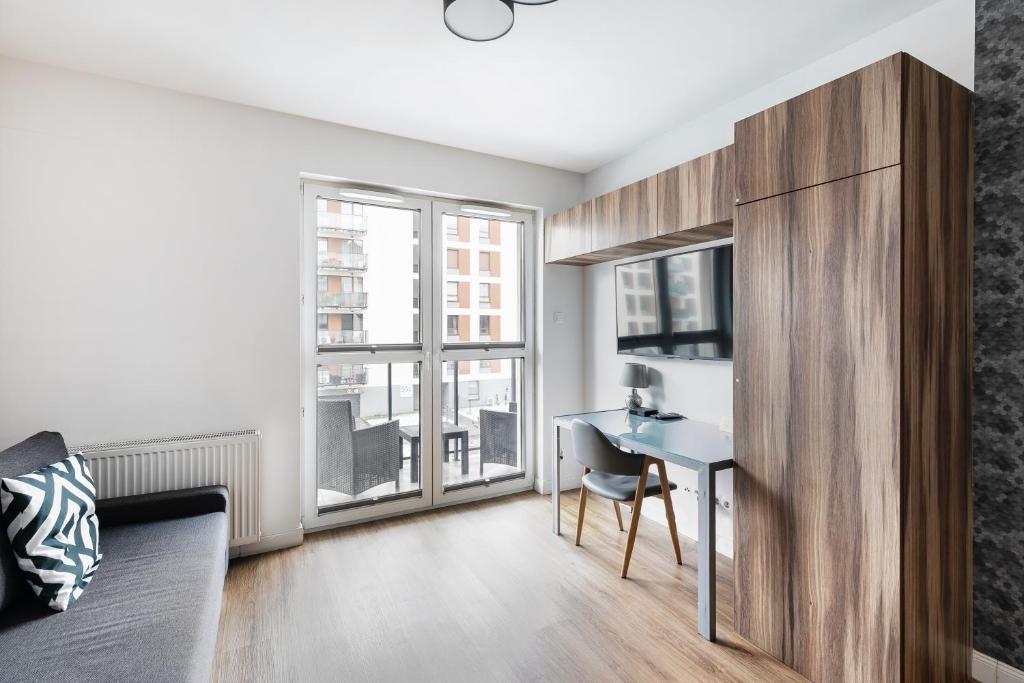 un soggiorno con scrivania e una camera da letto di Apartamenty Platinex 2 a Cracovia