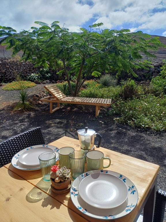 Una mesa de madera con dos platos encima. en Palacio Eco, en Tinajo
