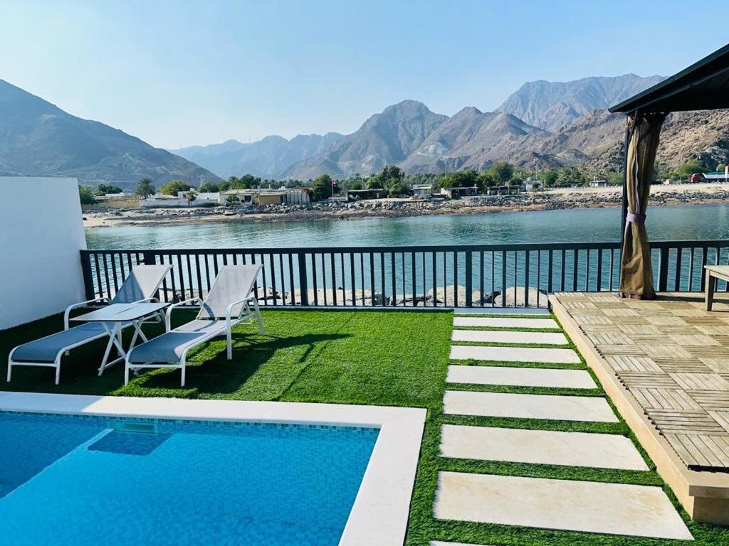 Una piscina con sillas y vista al agua. en The home 4, en Sharm