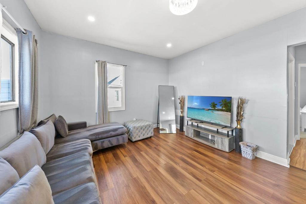 een woonkamer met een bank en een flatscreen-tv bij Cozy 3BR Home • Smart TV + Workspace in Dayton