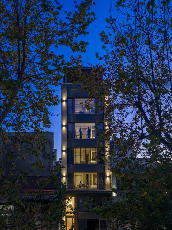 a tall building with lights on it at night at Kaoma Comfort Suites in Tríkala