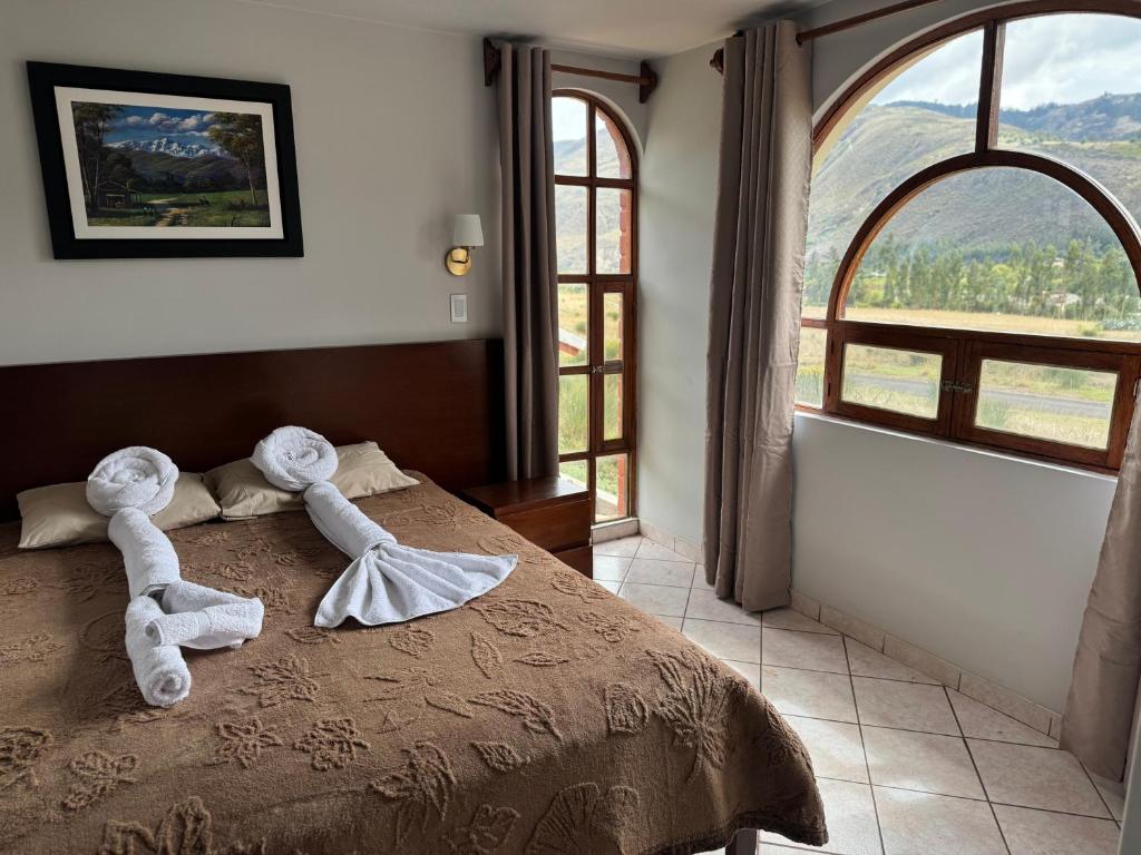 a bedroom with a bed with two dolls on it at Shumaq Guesthouse in Carhuaz