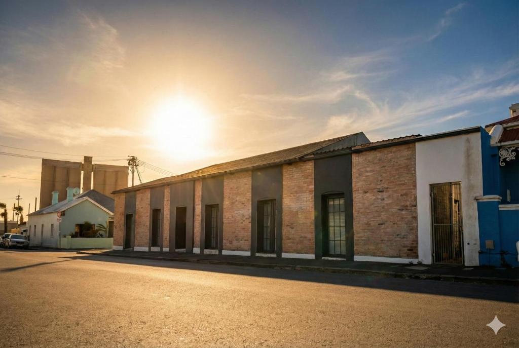 an old brick building with the sun in the sky at Modern Boho Loft- Observatory in Cape Town