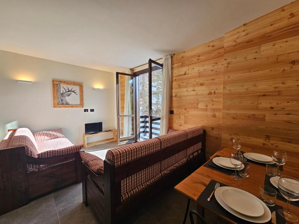 una sala de estar con un sofá y una mesa en Cimaboschi, en Sestriere