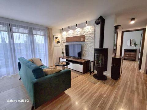 ein Wohnzimmer mit einer blauen Couch und einem Kamin in der Unterkunft Swiąteczny Apartament Rotembark in Rotembark