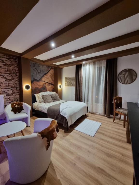 um quarto de hotel com uma cama, uma mesa e cadeiras em Esprit Chalet en centre ville Confort et charme em Tours