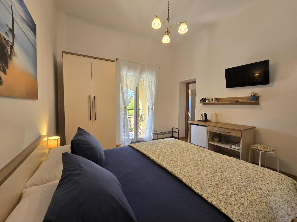 a bedroom with a large bed and a television at Apartments & Rooms Chiara in Rovinj