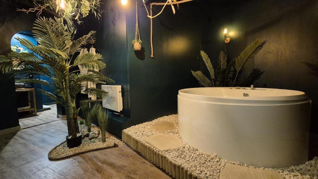a bathroom with a bath tub and plants in it at Amazonia - Private Spa and Cinema in Boulogne-sur-Mer