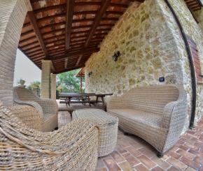 a patio with three wicker chairs and a table at Agriturismo Isola Verde in SantʼUrbano