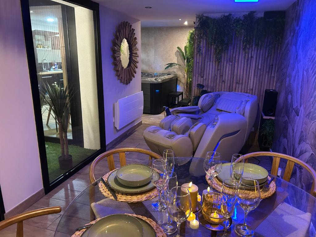 a dining room with a table and a couch at Thermo'Spa - Gîte Spa Privatif in Calais
