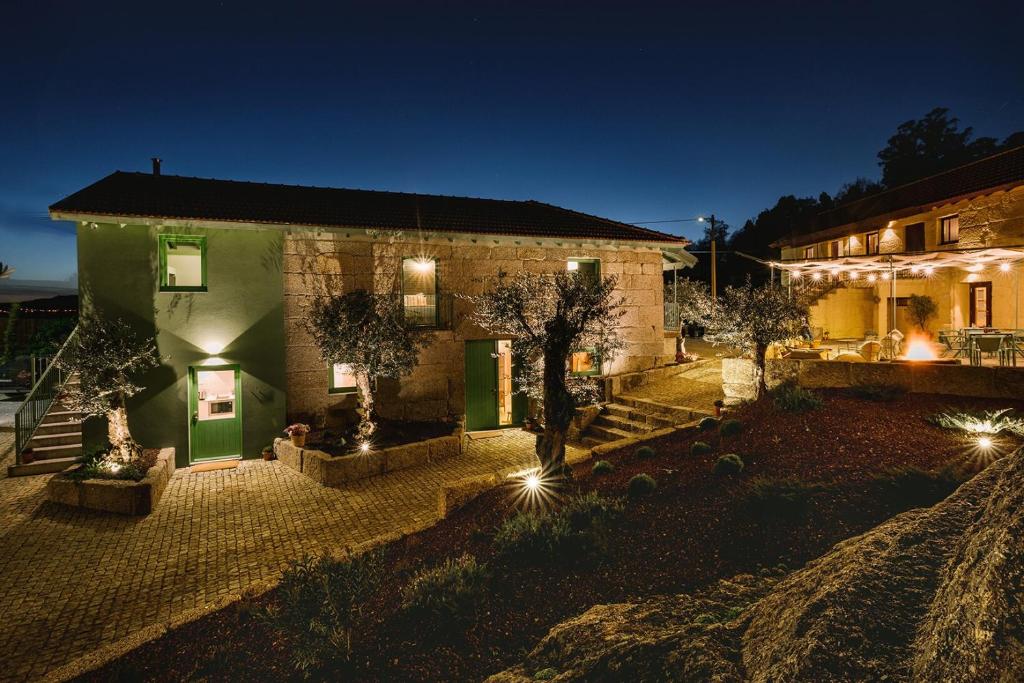 ein Haus mit einem Innenhof in der Nacht mit Lichtern in der Unterkunft Vila Coura in Amarante