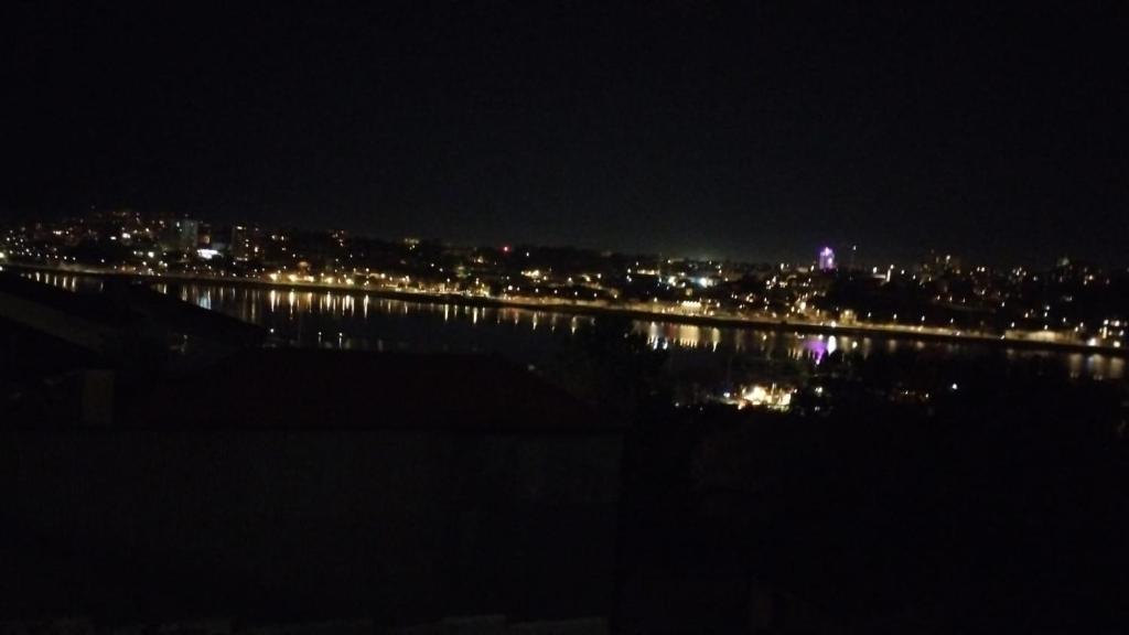 a view of a city at night with a body of water at Casa KAD in Vila Nova de Gaia