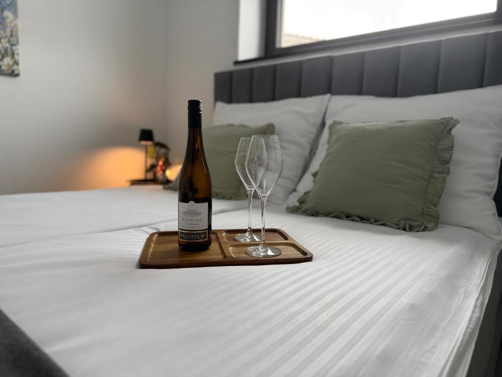 a bottle of wine and two glasses on a bed at Apartament u Bacy in Nowy Targ