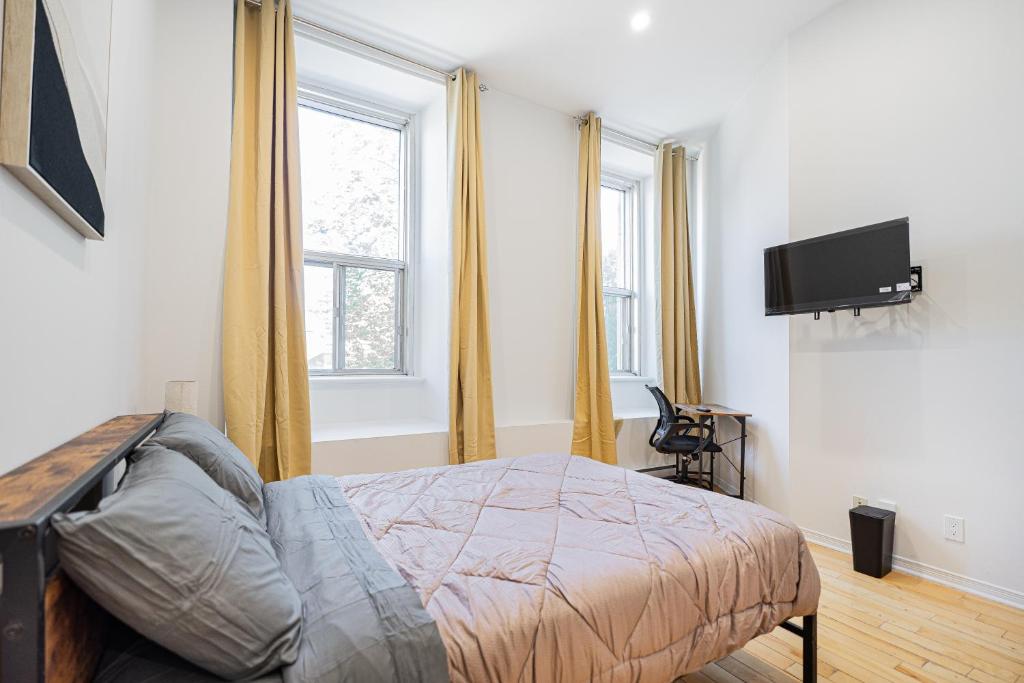 ein Schlafzimmer mit Bett und Flachbildfernseher in der Unterkunft Sunny Corner studio for 2 Guest with Parking in Montreal
