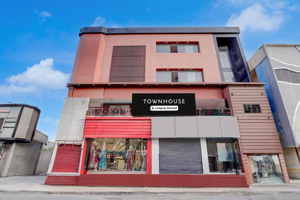 Un edificio alto de color rosa con un cartel. en Collection O Haridwar Railway Station Formerly Le Central, en Haridwar