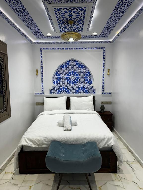 a bedroom with a bed with a blue and white ceiling at Dar Ouadie Serene Blue in Chefchaouen