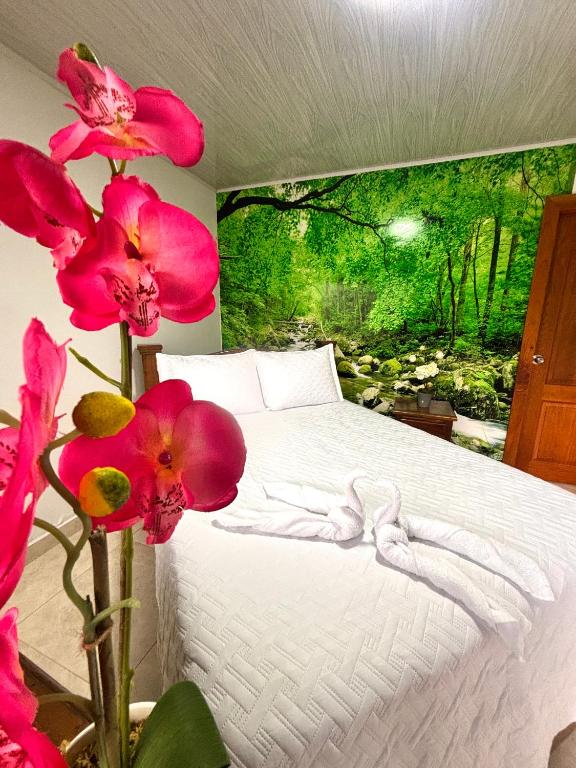 a bedroom with a bed with pink flowers at Hotel Sleep Well in Filandia