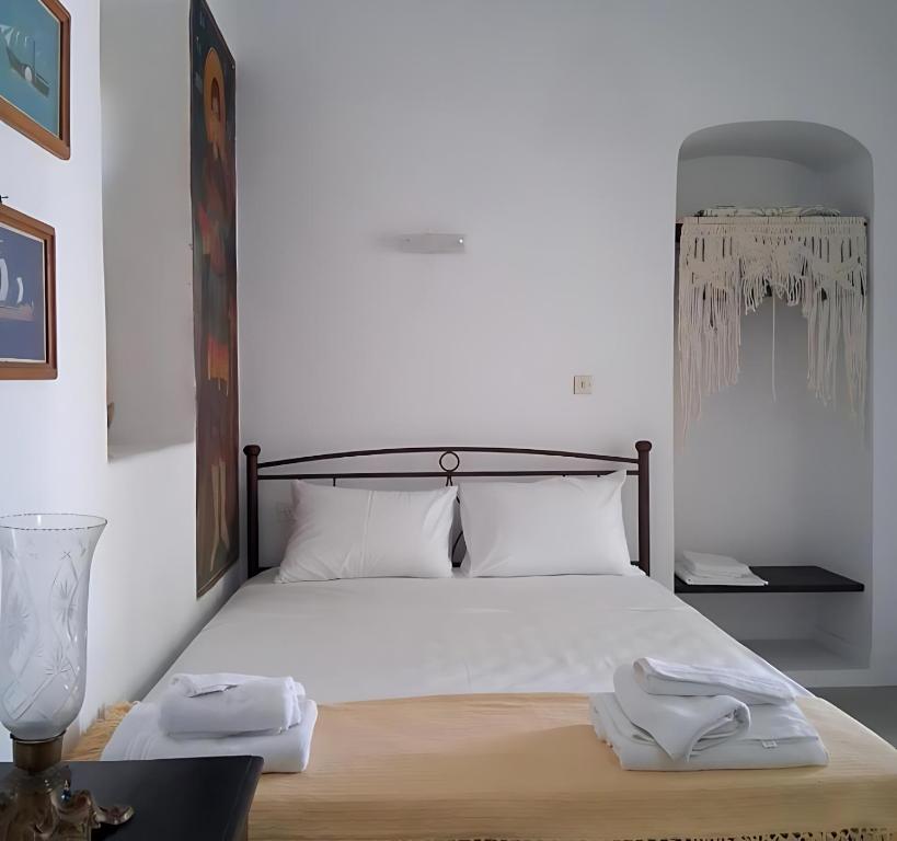 a bedroom with a bed with two towels on it at Aegaia Residencies in Katapola
