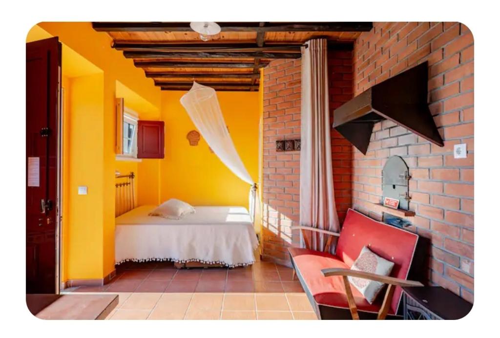 a bedroom with a bed and a yellow wall at Casa na Floresta in Figueira da Foz