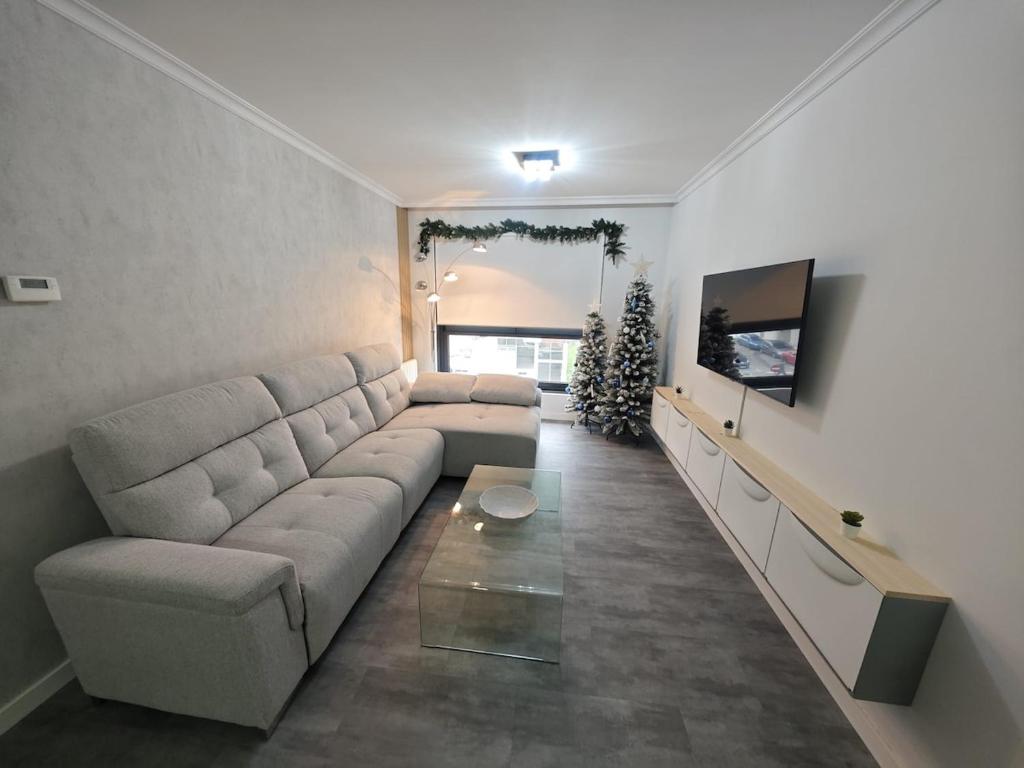 a living room with a couch and a christmas tree at Doña Urraca in Porriño